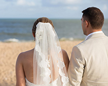 couple in wedding clothes looking at the sea